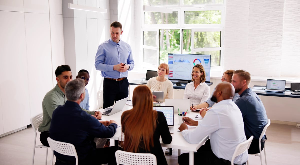 Business people, seminar and convention with audience, question and interaction for feedback or engagement. Group, speaker and back of employee with hand raised for proposal or speech at presentation