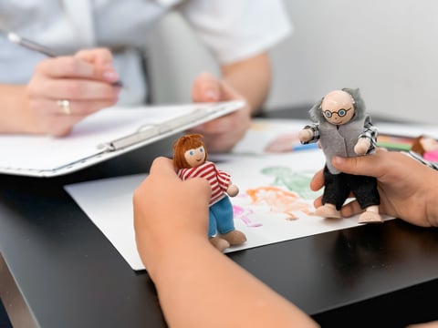 Child therapy session with therapist using puppet play for emotional expression