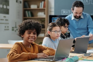 Group of children studying in classroom with laptops, educational atmosphere