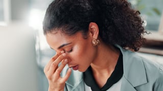 Businesswoman with headache burnout migraine overworked stressed in office