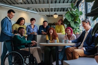 Happy multiracial colleagues with wheelchair in inclusive workplace bonding laughing