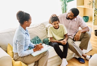Father with teenage son meeting with social worker psychologist family therapy